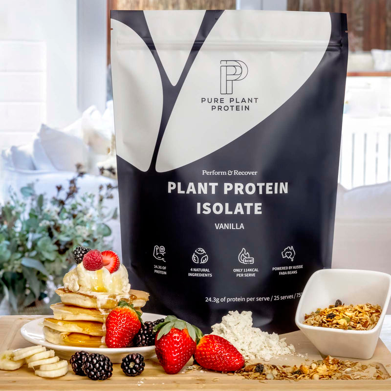 Pure Plant Protein package with a stack of pancakes, berries, and granola on a table.