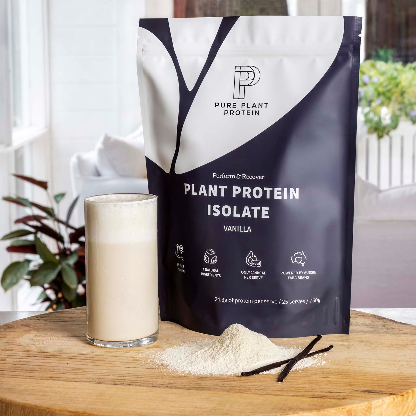Pure Plant Protein plant protein isolate package with a glass of vanilla protein shake on a wooden surface.