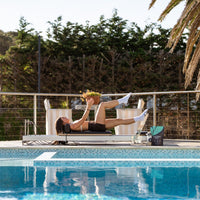 Person exercising by a pool with palm trees in the background
