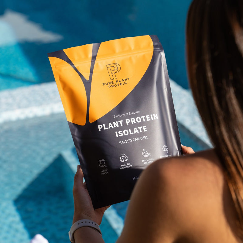 Salted Caramel Plant Protein Powder in front of a pool