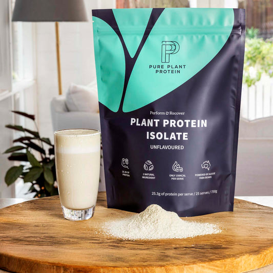 Pure Plant Protein plant protein isolate package with a glass of protein shake on a wooden surface.